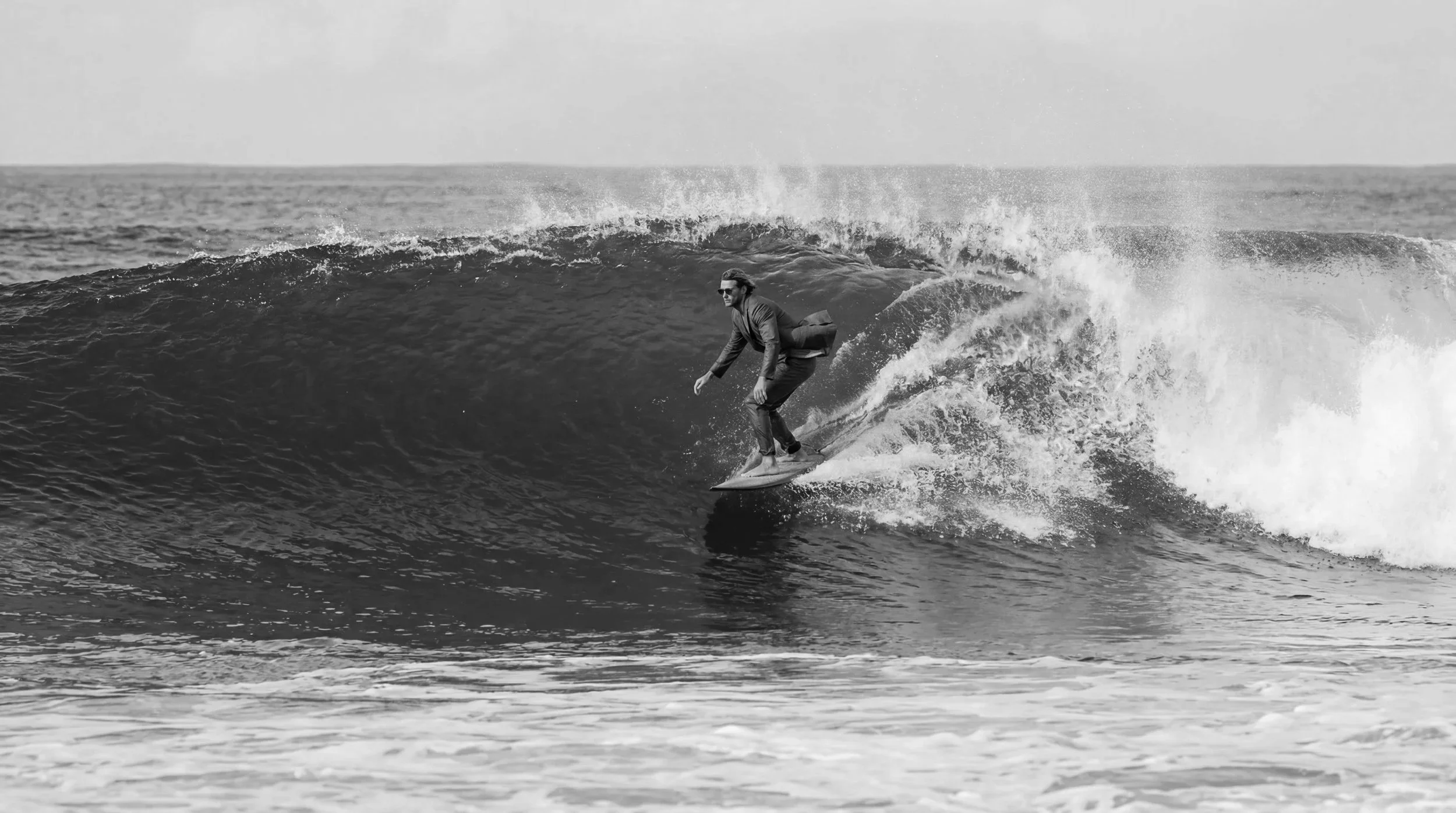 A surfer wearing Lazell sunglasses in the ocean